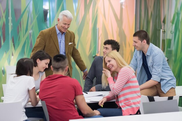 grupo de estudiantes estudian con el profesor en el aula de la escuela moderna