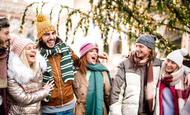 Grupo de estudiantes felices caminando en la ciudad en un día soleado de invierno