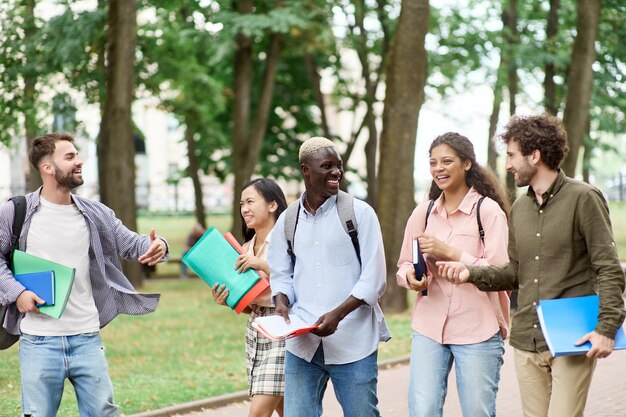 Grupo de estudiantes felices caminando por el parque