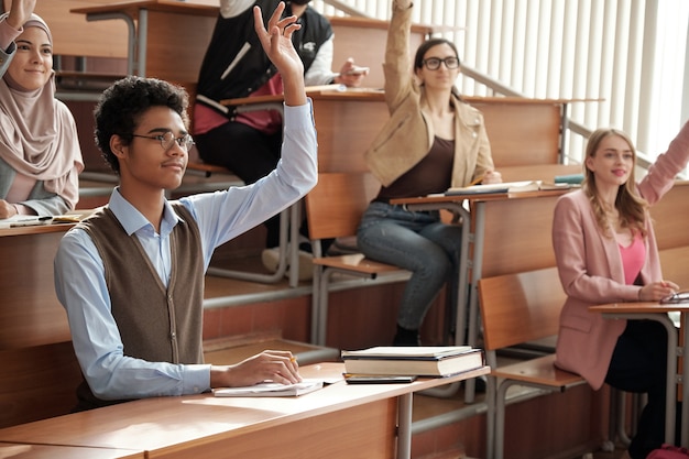 Foto grupo de estudiantes interculturales levantando las manos en la lección