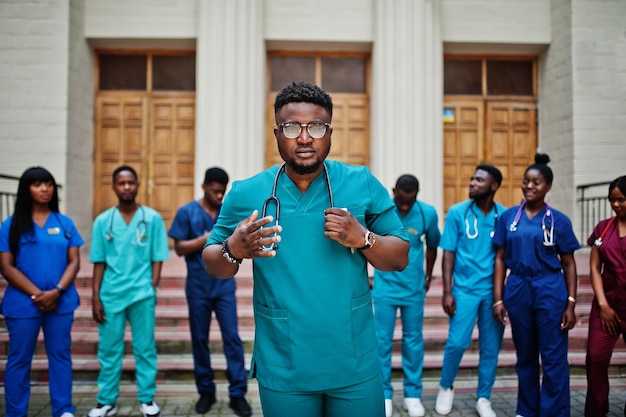 Grupo de estudiantes de medicina africanos posaron al aire libre contra la puerta de la universidad