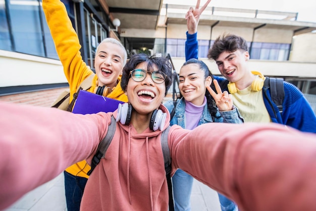 Grupo de estudiantes multirraciales tomando fotos selfie en la escuela