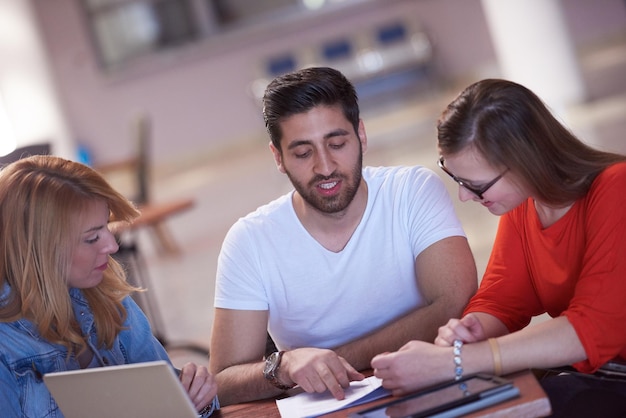 Foto grupo de estudiantes que trabajan juntos en un proyecto escolar en una computadora tablet en una universidad moderna