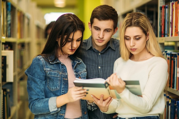 Foto un grupo de estudiantes quiere encontrar literatura útil para prepararse para el examen universitario