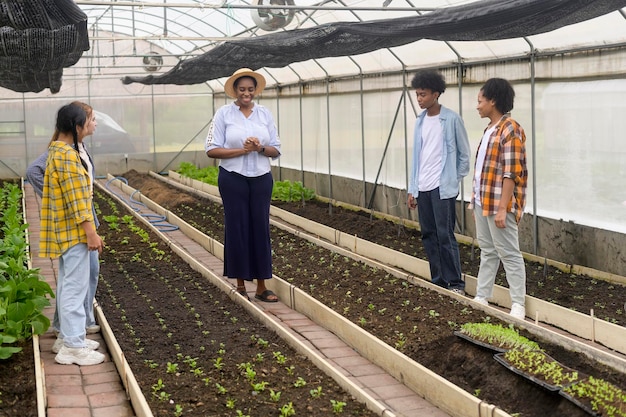 Grupo de estudiantes de raza mixta y profesores aprendiendo tecnología agrícola en agricultura inteligente