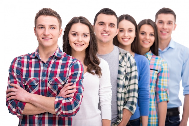 Grupo de estudiantes sonrientes están de pie.