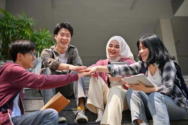 Un grupo de estudiantes universitarios de Asiandiverse juntando sus manos