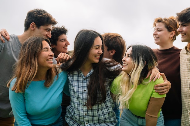 Grupo de estudiantes universitarios sonriendo el uno al otro campus