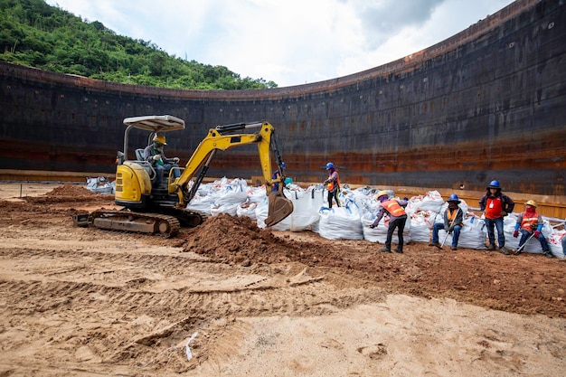 Grupo de excavación de trabajadores e ingenieros de construcción en el aceite del tanque inferior