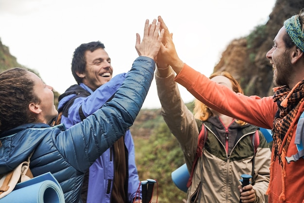 Grupo de excursionistas felices apilando las manos al aire libre