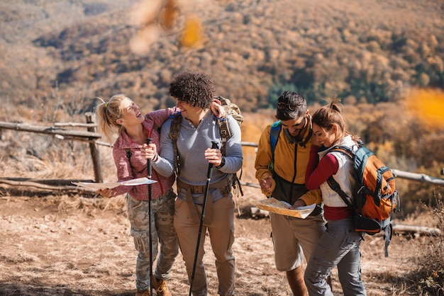 Grupo de excursionistas de pie mirando mapas. Otoño.