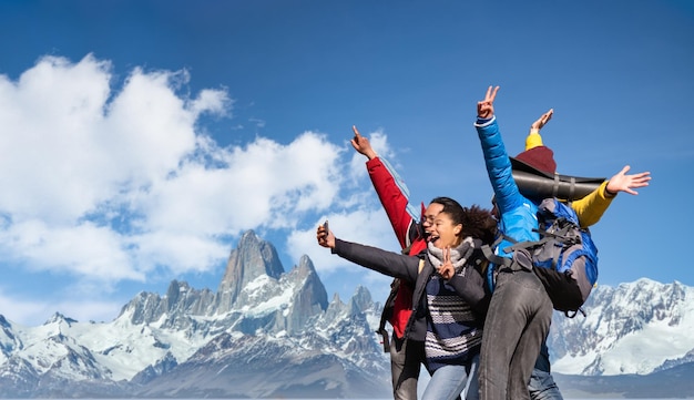 Grupo de excursionistas tomando selfie en montañas nevadas Amigos felices con las manos en alto divirtiéndose juntos Gente multiétnica teniendo un día de trekking juntos