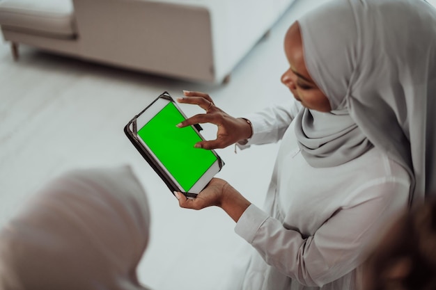 Grupo de felices estudiantes africanos que tienen una conversación y una reunión de equipo trabajando juntos en las tareas de las niñas que usan la moda tradicional de hiyab musulmán de Sudán. foto de alta calidad