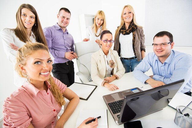 Grupo de felices y exitosos empresarios en la oficina mirando a la cámara.