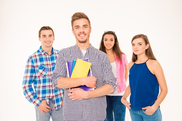 Grupo feliz de alunos segurando livros