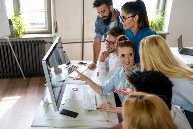Un grupo feliz y exitoso de personas que aprenden ingeniería de software y negocios durante la presentación