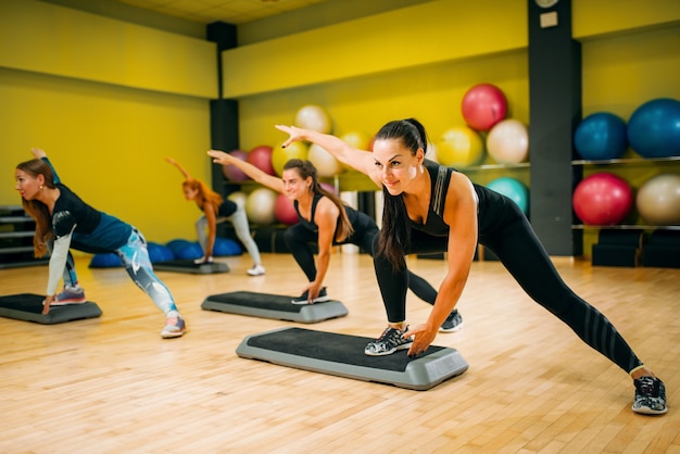 Grupo feminino em treino aeróbico de step