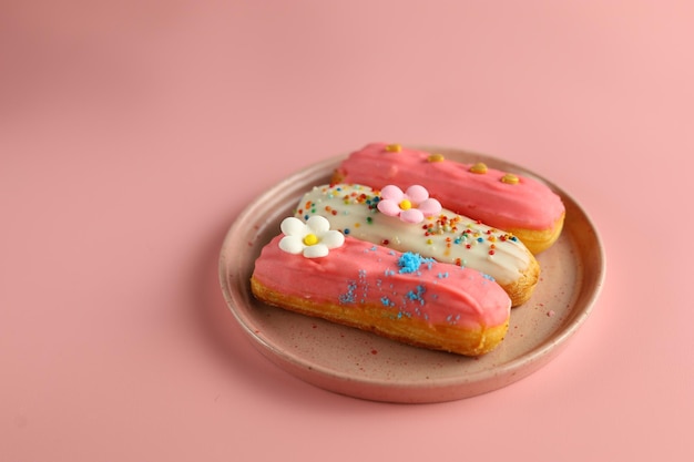 Grupo de Fench delicioso postre Eclair con color rosa sobre fondo rosa para el concepto de San Valentín