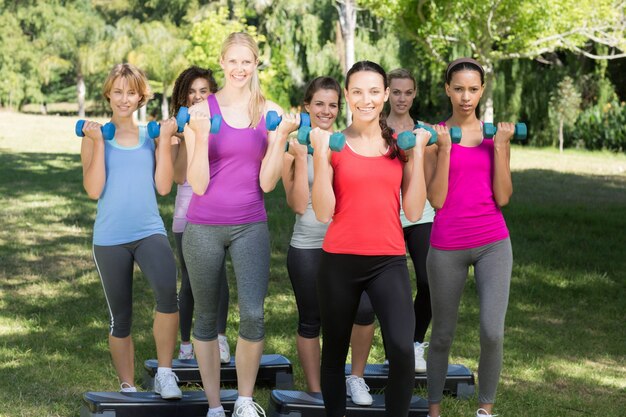 Grupo de fitness levantando pesas de mano en el parque