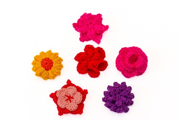 Grupo de flores de colores tejidas a ganchillo como pinzas para el cabello