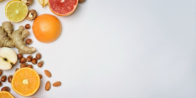 Grupo de fruta naranja cruda sobre fondo blanco.