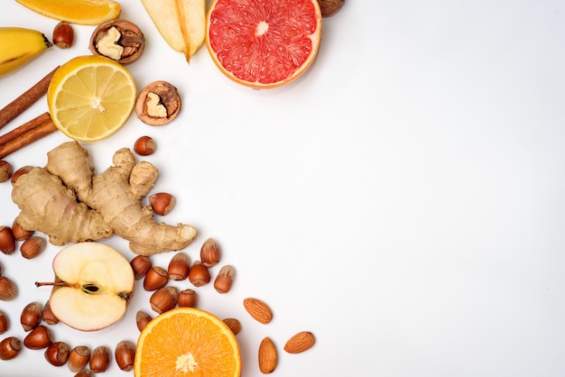 Grupo de fruta naranja cruda sobre fondo blanco.