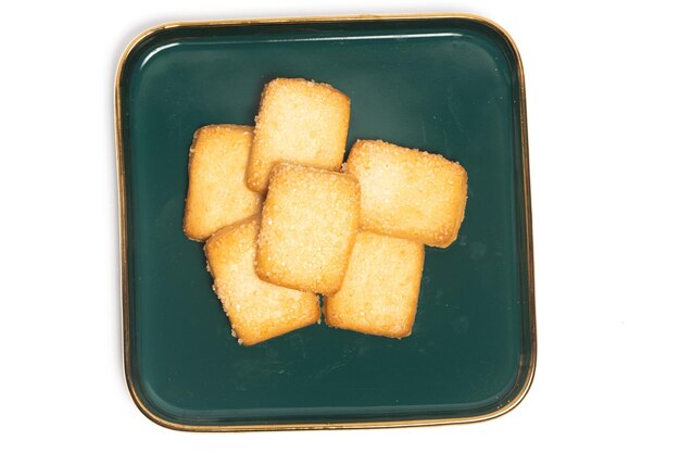 Grupo de galletas de mantequilla danesa la galleta de pan finlandesa en un plato verde vista superior aislada