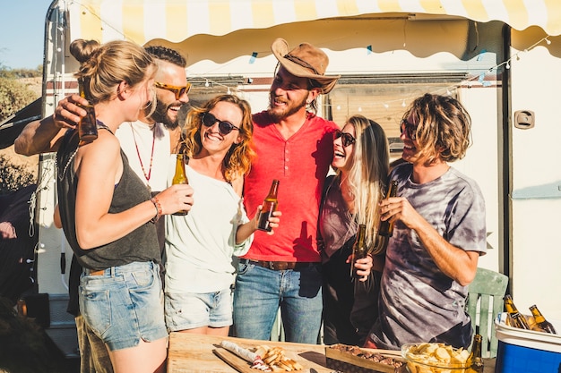 Foto grupo de gente alegre, jóvenes, hombres y mujeres jóvenes se divierten juntos en amistad con cervezas