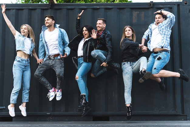 Grupo de gente joven y elegante saltando en el aire en una calle de la ciudad