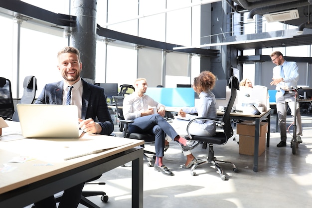 Grupo de gente de negocios progresiva feliz trabajando juntos en la puesta en marcha en la oficina creativa.