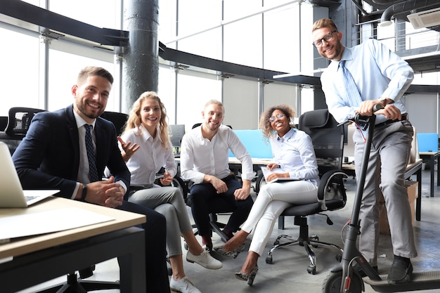 Grupo de gente de negocios progresiva feliz trabajando juntos en la puesta en marcha en la oficina creativa.