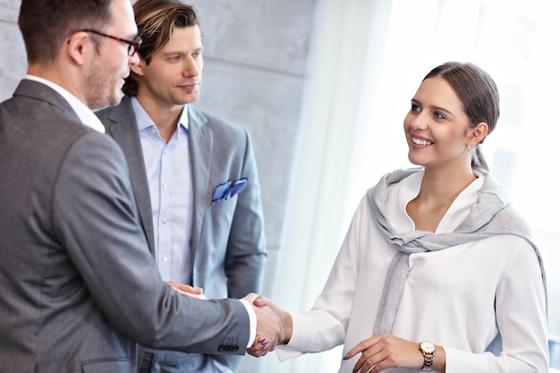 Grupo de gente de negocios que se presentan unos a otros en la oficina moderna