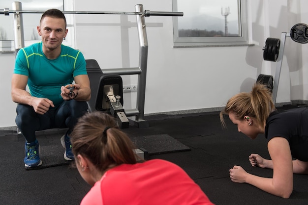 Grupo de gente sonriente haciendo ejercicio en el gimnasio.