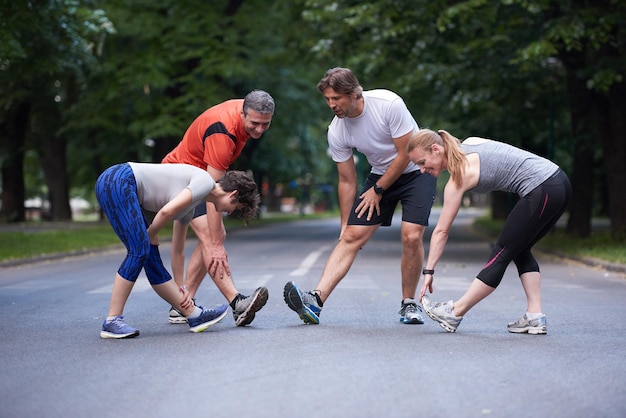 grupo de gente trotando estirándose en el parque antes de entrenar