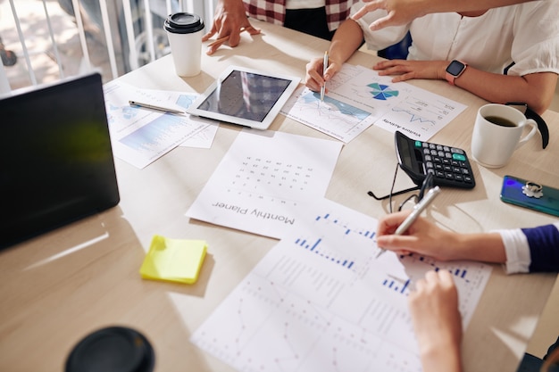 Grupo de gerentes discutiendo gráficos y diagramas en una reunión en la oficina cuando se trabaja en una estrategia de marketing