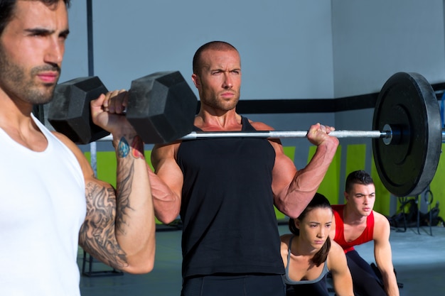 Grupo de gimnasia con barra de levantamiento de pesas, entrenamiento crossfit.