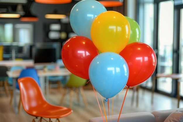Un grupo de globos de varios colores, incluido el rojo, el amarillo, el azul y el verde, decoran un evento de la oficina. Los globos están atados y flotan en el aire.