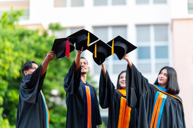 Un grupo de graduados universitarios se puso un sombrero negro y los felicitó el día de la graduación.