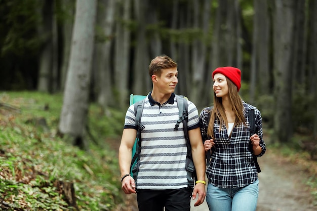 Grupo de hombres y mujeres durante una excursión de senderismo en el bosque caminando mientras disfrutan de su viaje