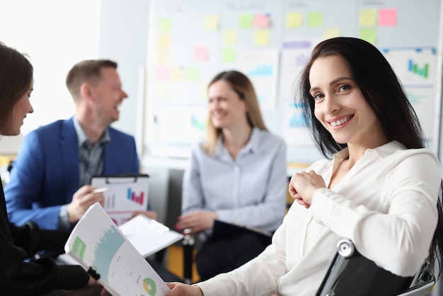 Grupo de hombres y mujeres sentados con documentos en manos en cursos de formación empresarial