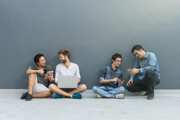 Foto grupo de hombres de negocios asiáticos y multiétnicos con trajes casuales usando cada tecnología
