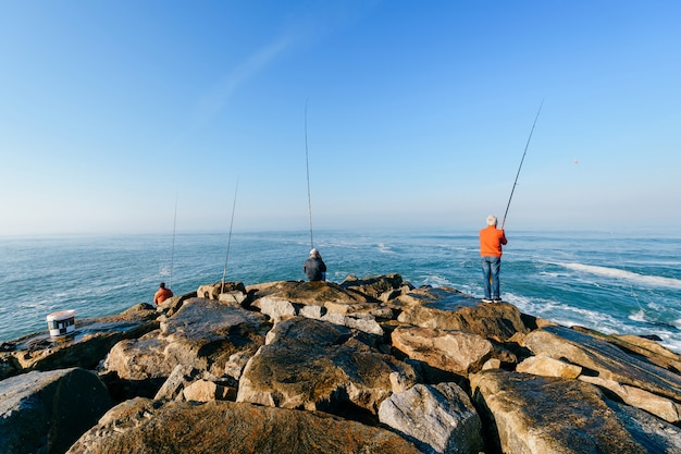 Grupo de hombres pescando en el océano