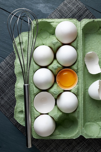 Grupo de huevos de gallina blanca cruda en bandeja de papel verde