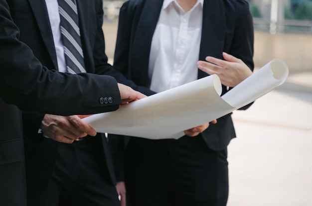 Grupo de ingeniero de la mujer y el hombre con el plan de planificación sobre el nuevo plan de construcción del proyecto