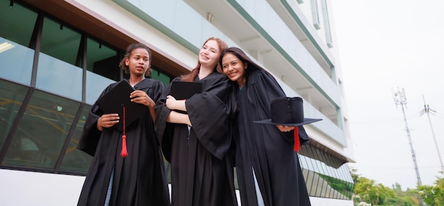 Grupo joven estudiante vistiendo bata y graduándose Feliz éxito y celebración de graduados Felicitaciones