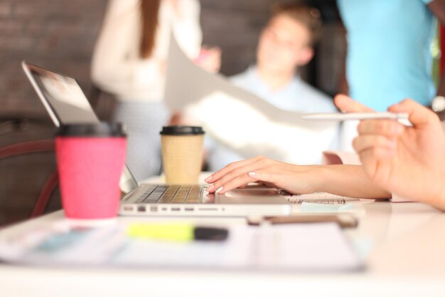 Grupo joven de personas que hacen su trabajo en la computadora portátil.