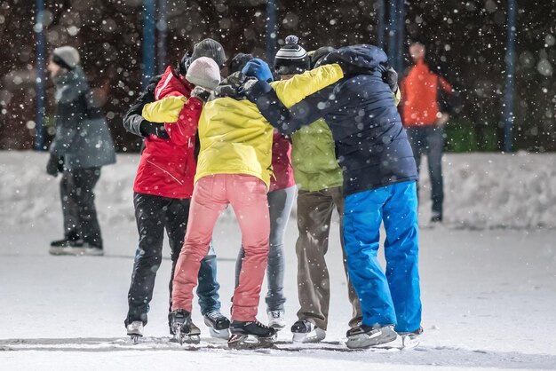 Un grupo de jóvenes se abrazan en una pista de patinaje