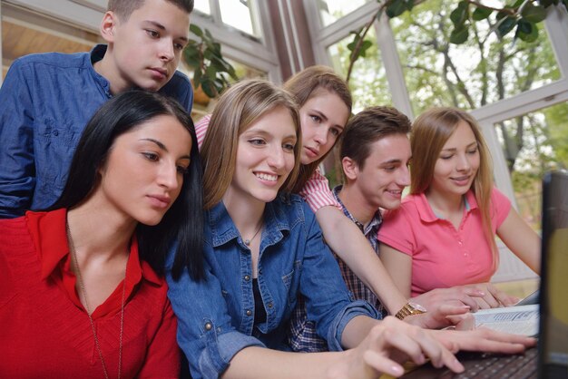 Foto un grupo de jóvenes adolescentes felices en la escuela se divierten y aprenden lecciones