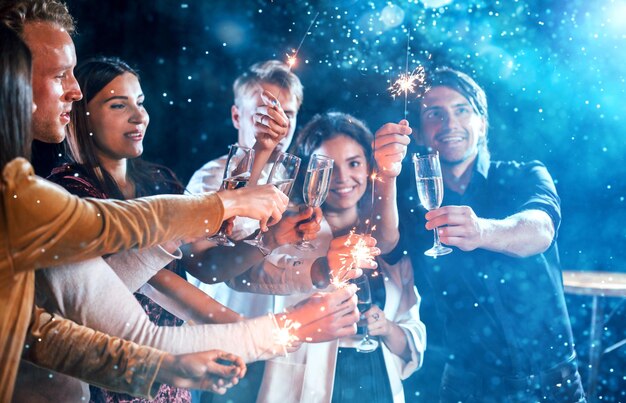 Foto un grupo de jóvenes alegres tienen una fiesta y celebran el año nuevo en el interior