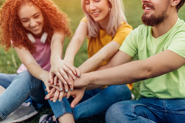 Foto grupo de jóvenes amigos cogidos de la mano juntos como equipo